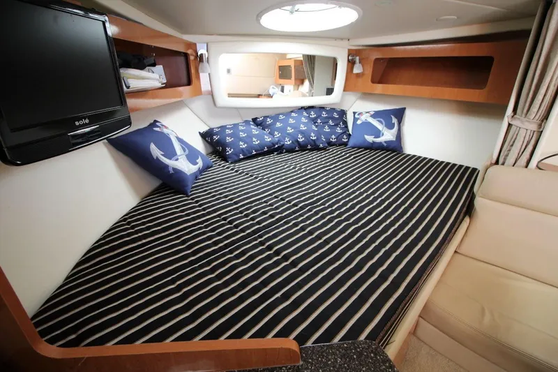 Slide: The Image of Cozy cabin interior of 2008 Maxum 2900 SE with striped bedding and nautical decor. - 30
