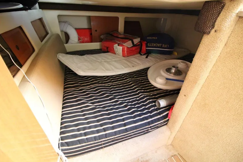 Slide: The Image of 2008 Maxum 2900 SE cabin interior with striped bedding and safety equipment. - 31