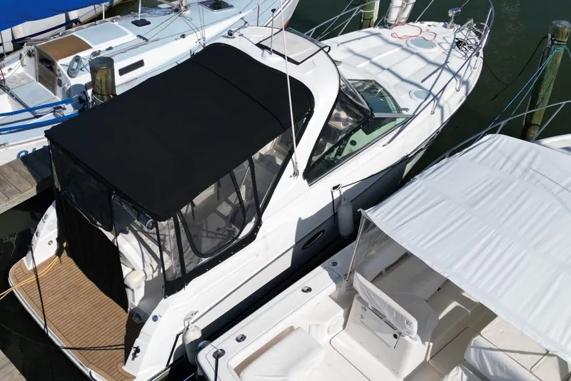 Slide: The Image of 2008 Maxum 2900 SE boat docked with black canopy and white deck. - 7