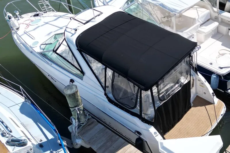 Slide: The Image of 2008 Maxum 2900 SE boat docked with black canopy and white hull. - 9