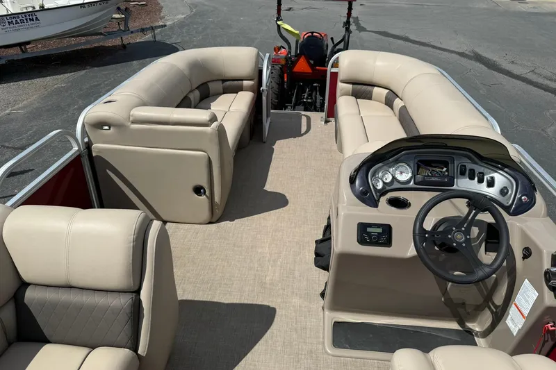 Slide: The Image of 2023 Sun Tracker Party Barge 20 DLX interior with beige seating and steering console. - 15