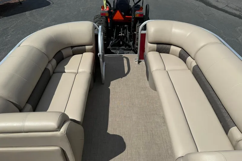Slide: The Image of 2023 Sun Tracker Party Barge 20 DLX interior with beige seating and spacious layout. - 17