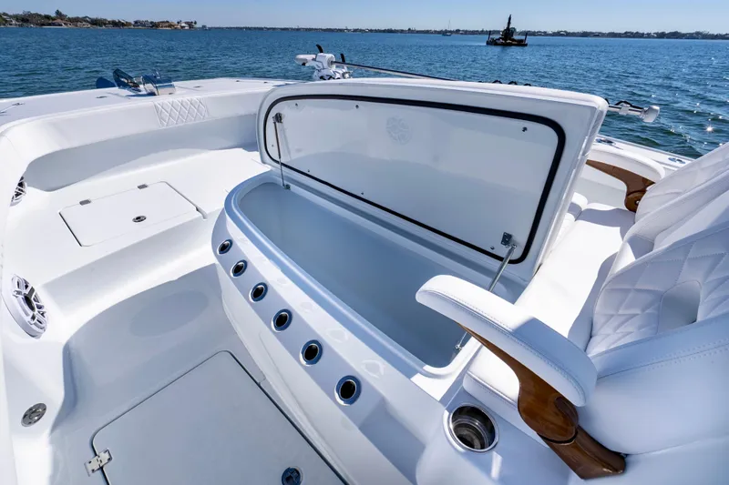 Slide: The Image of Luxurious 2026 Freeman 35 boat interior with open storage compartment, white seating, and ocean view. - 26