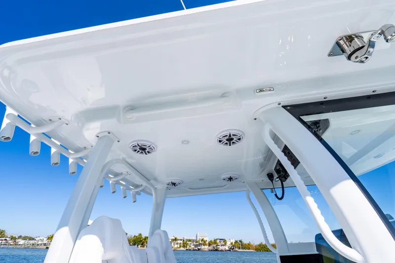 Slide: The Image of 2026 Freeman 35 boat interior with rod holders and speakers, under clear blue sky. - 34