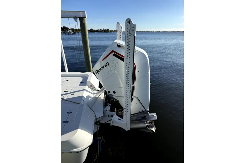 Slide: The Image of 2024 Contender 25 Bay boat with powerful outboard motor on calm water. - 10