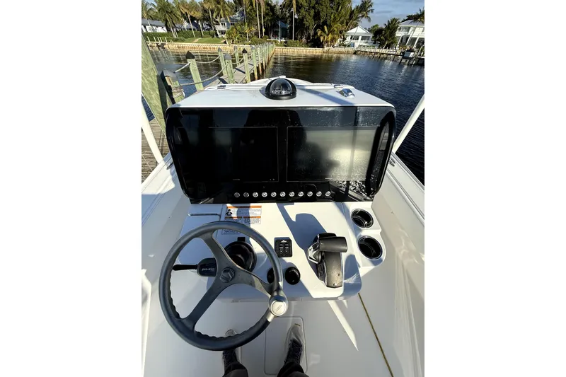 Slide: The Image of 2024 Contender 25 Bay boat dashboard with steering wheel and control panel. - 14