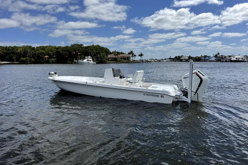 Slide: The Image of 2024 Contender 26 Bay boat on calm water under a partly cloudy sky. - 2