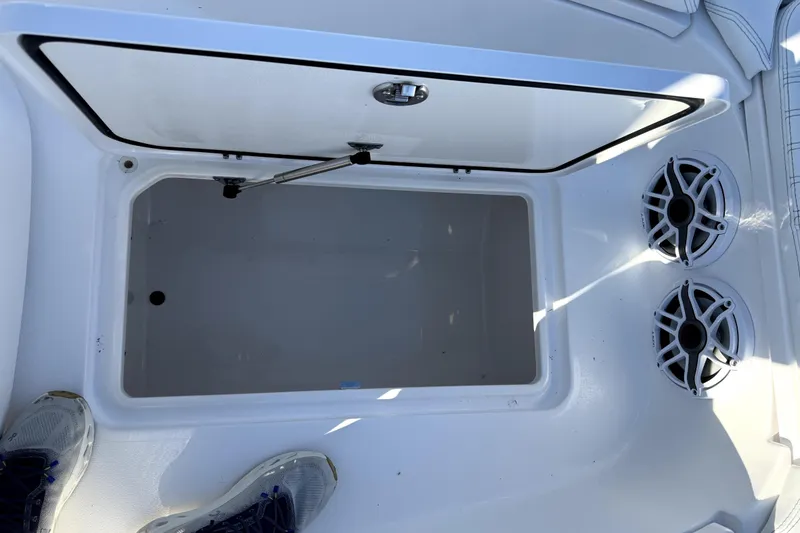 Slide: The Image of 2024 Contender 25 Bay boat storage compartment with speakers and open hatch. - 22