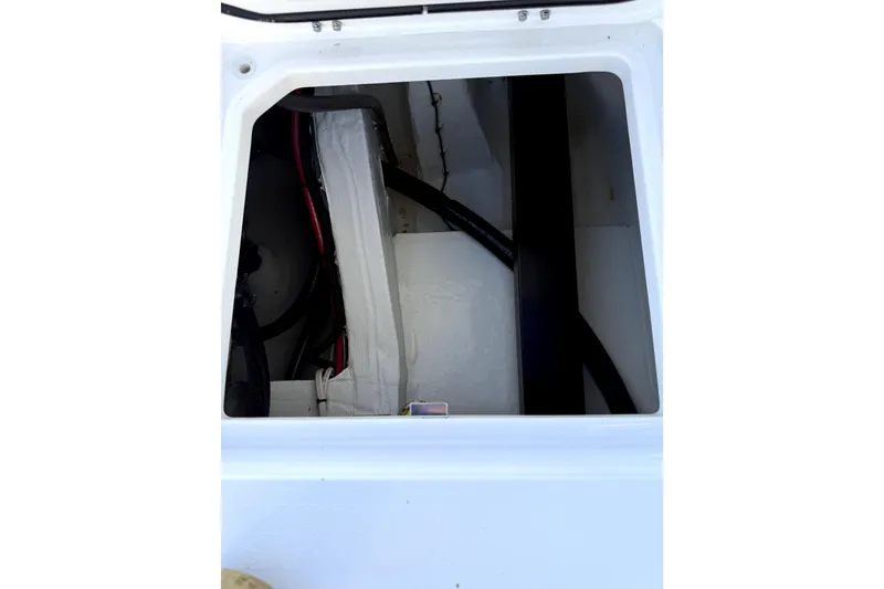 Slide: The Image of 2024 Contender 25 Bay boat storage compartment with wiring and equipment. - 25
