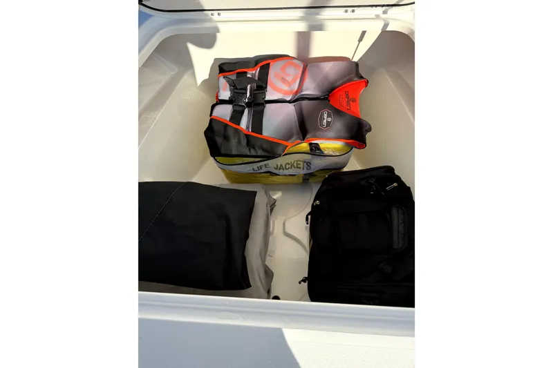 Slide: The Image of Storage compartment of 2024 Contender 25 Bay boat with life jackets and bags. - 27