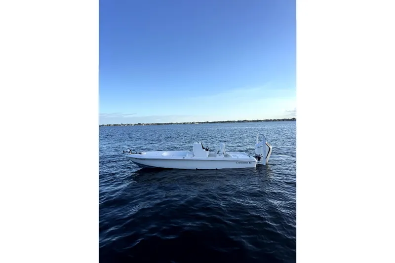 Slide: The Image of 2024 Contender 26 Bay boat on calm blue water under clear sky. - 4
