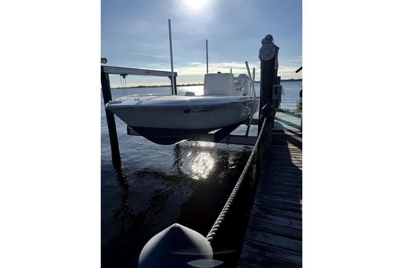 Slide: The Image of 2024 Contender 25 Bay boat docked at sunset, reflecting on calm water. - 5