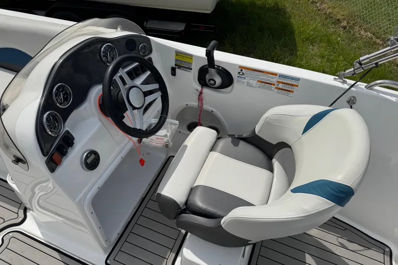 Slide: The Image of 2019 Hurricane SunDeck Sport 202 IO boat cockpit with steering wheel and cushioned seat. - 15