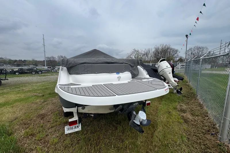 Slide: The Image of 2019 Hurricane SunDeck Sport 202 IO boat, covered and parked on grass near a fence. - 5