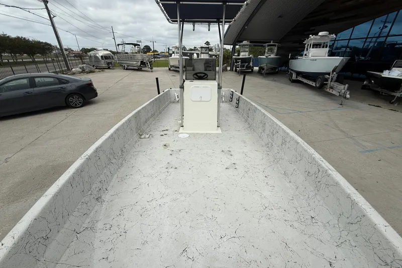 Slide: The Image of 1991 Avenger 210 Bay Runner boat interior with center console, parked outdoors. - 11