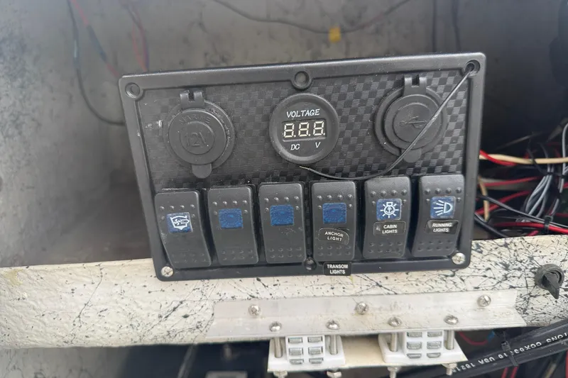 Slide: The Image of Control panel of a 1991 Avenger 210 Bay Runner boat with voltage display and switches. - 14