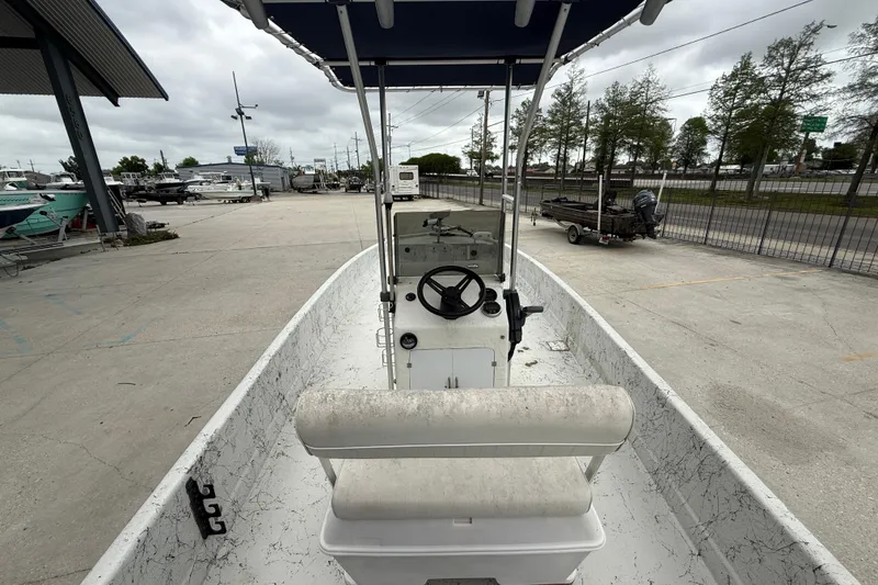 Slide: The Image of 1991 Avenger 210 Bay Runner boat with center console and seating, parked outdoors. - 7