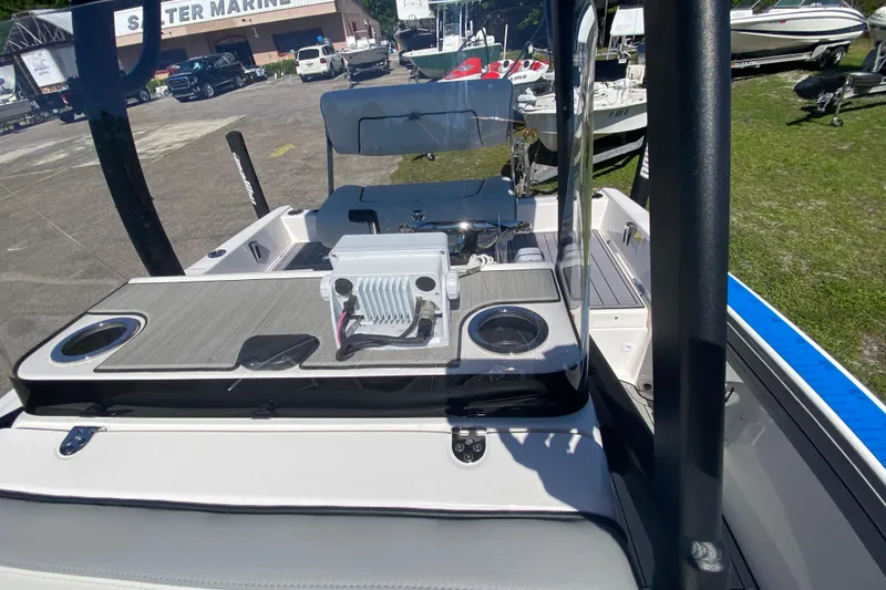 Slide: The Image of 2023 Yamaha Boats 195 FSH Sport interior with seating and console, displayed outdoors. - 5