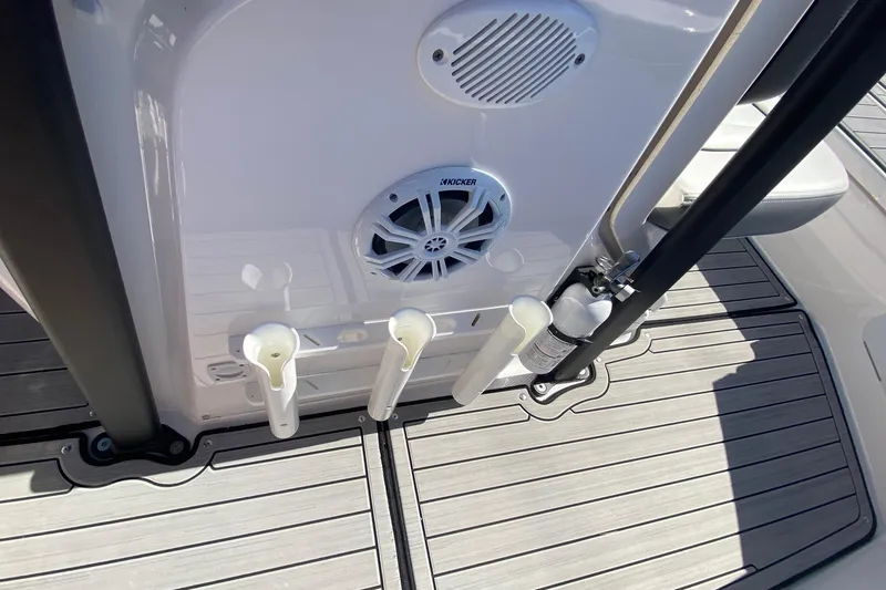 Slide: The Image of 2023 Yamaha Boats 195 FSH Sport deck with speaker, rod holders, and fire extinguisher. - 8