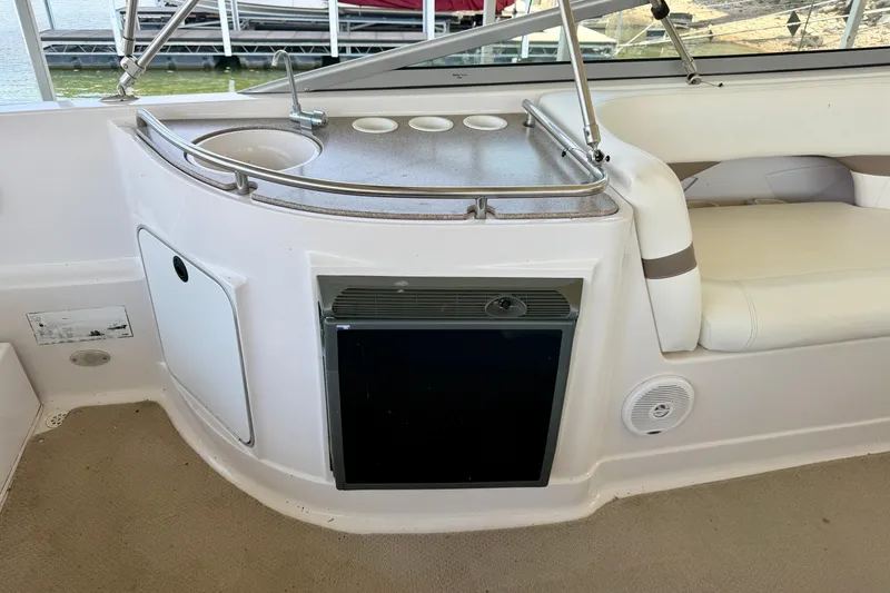Slide: The Image of 2004 Four Winns 280 Horizon boat interior with mini fridge and seating area. - 10
