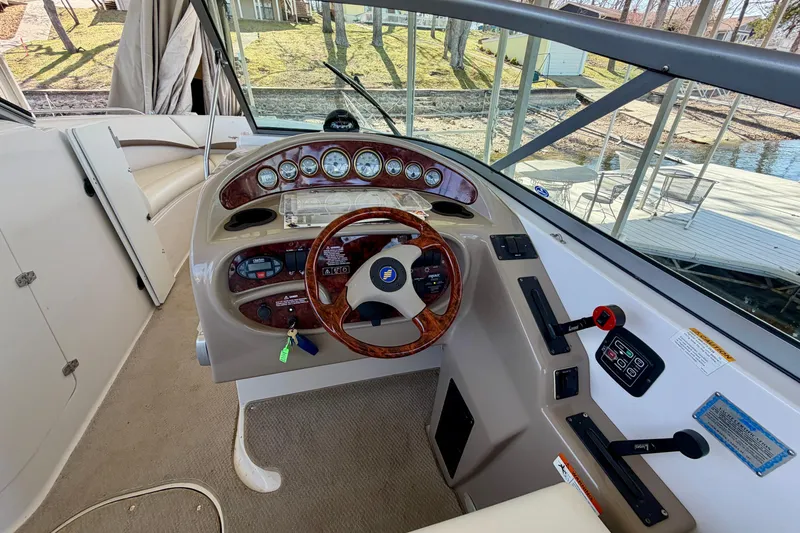 Slide: The Image of 2004 Four Winns 280 Horizon boat helm with wood-accented steering wheel and instrument panel. - 12