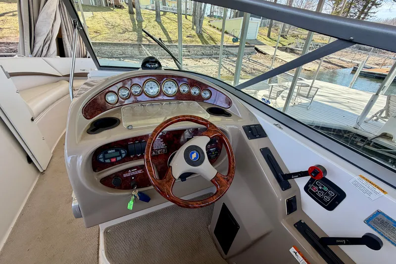 Slide: The Image of 2004 Four Winns 280 Horizon boat helm with wood-accented steering wheel and instrument panel. - 13