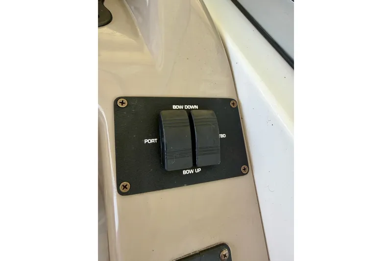 Slide: The Image of Control panel on a 2004 Four Winns 280 Horizon boat, featuring bow adjustment switches. - 15