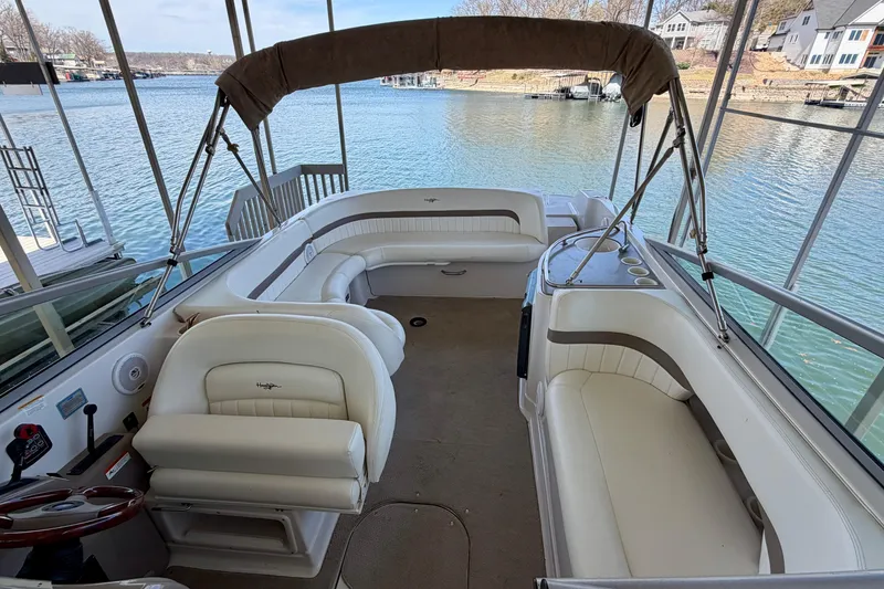 Slide: The Image of 2004 Four Winns 280 Horizon boat interior with white seating and canopy on a calm lake. - 22