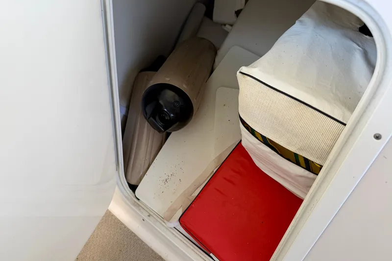 Slide: The Image of Storage compartment in a 2004 Four Winns 280 Horizon boat with fender and cushions. - 26