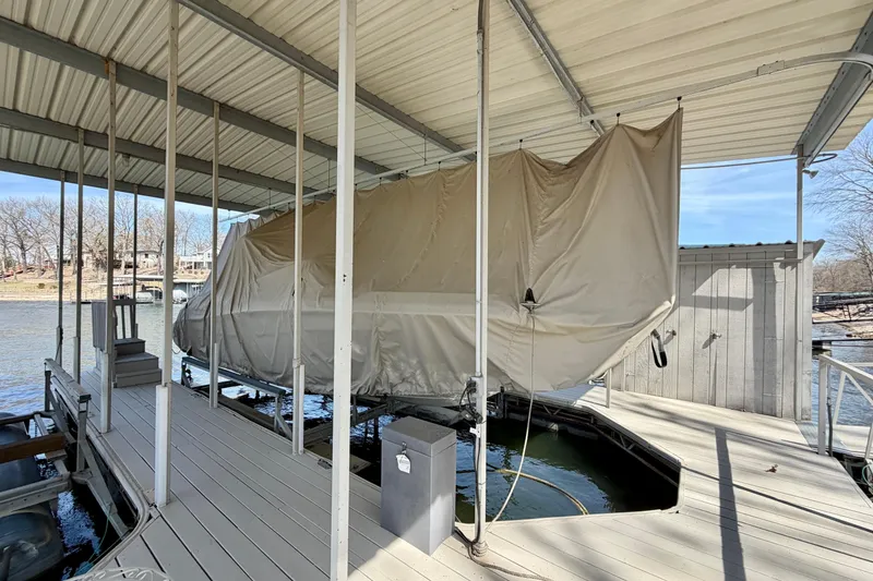 Slide: The Image of Covered 2004 Four Winns 280 Horizon boat docked under a shelter by the water. - 3