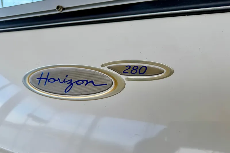 Slide: The Image of 2004 Four Winns 280 Horizon boat emblem on white surface. - 4