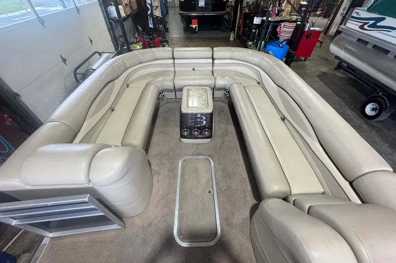 Slide: The Image of Luxurious seating area on a 2010 Bennington 2550RCW pontoon boat in a garage setting. - 10