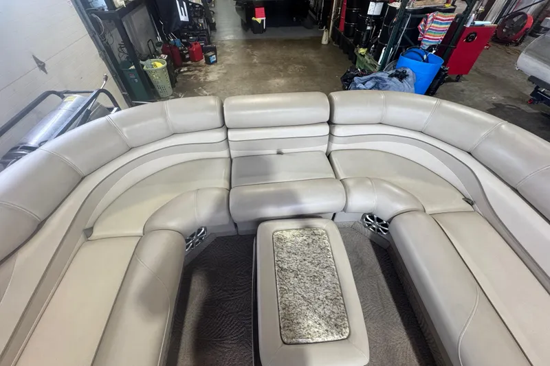 Slide: The Image of Luxurious seating area on a 2010 Bennington 2550RCW boat, featuring plush upholstery and a central table. - 13