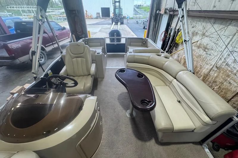 Slide: The Image of Interior of a 2010 Bennington 2550RCW pontoon boat with beige seating and steering console. - 15