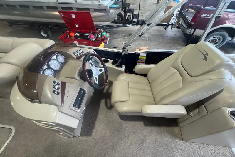 Slide: The Image of 2010 Bennington 2550RCW boat interior with steering console and beige captain's chair. - 16