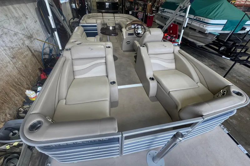 Slide: The Image of 2010 Bennington 2550RCW pontoon boat with beige seating in a storage area. - 25