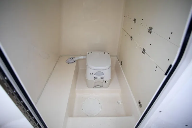 Slide: The Image of Manufacturer Provided Image: 2025 Sea Born LX26 Center Console boat interior with compact marine toilet. - 6