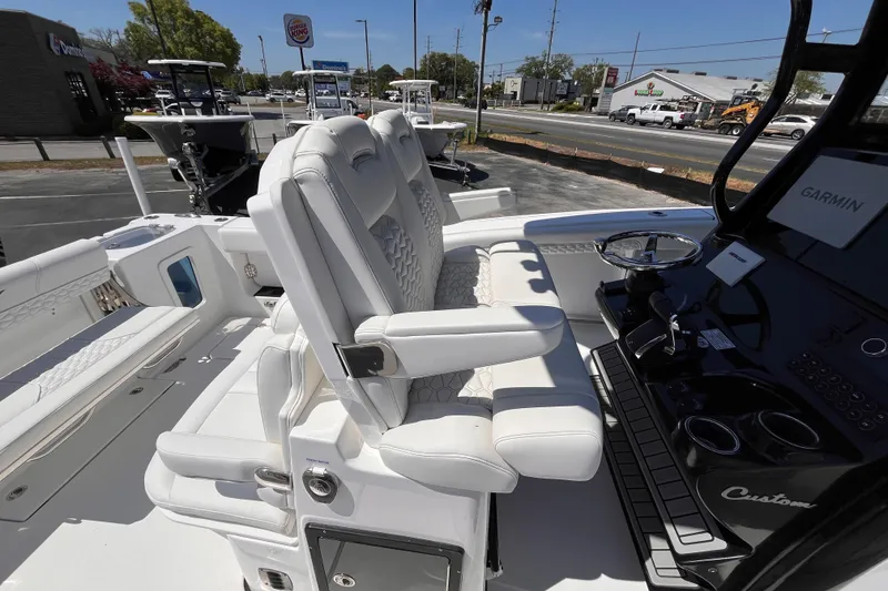 Slide: The Image of 2026 Tidewater 282 CC Adventure boat interior with white seating and Garmin dashboard. - 16