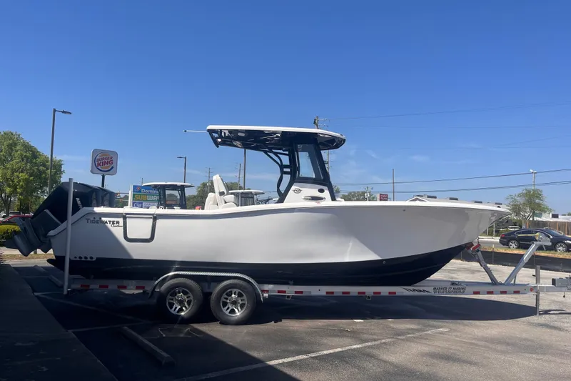 Slide: The Image of 2026 Tidewater 282 CC Adventure boat on trailer in parking lot, clear sky background. - 4