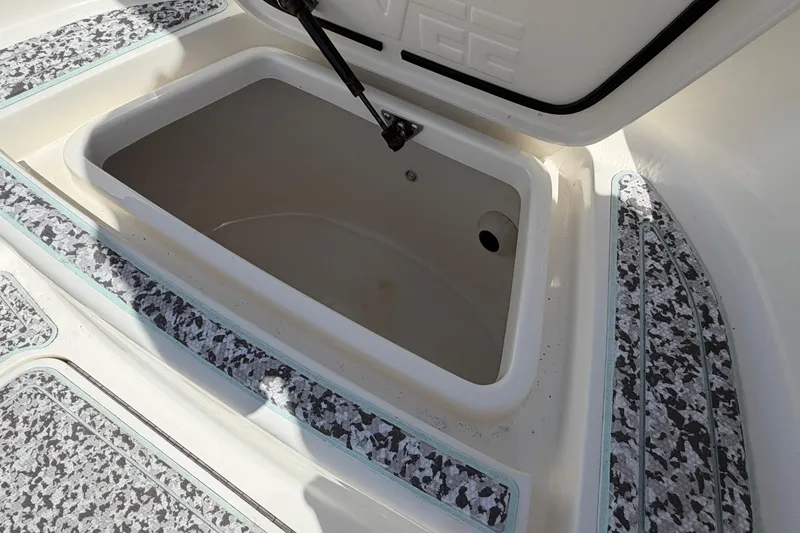 Slide: The Image of Open storage compartment on a 2019 Sea Vee 270Z boat, featuring textured flooring. - 26