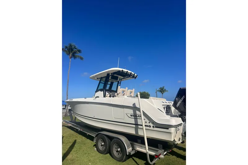 The Image of 2023 Boston Whaler 280 Outrage boat on trailer under clear blue sky. - 1