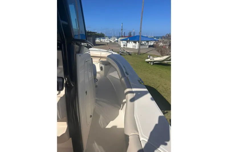 Slide: The Image of 2023 Boston Whaler 280 Outrage boat docked at a marina under clear blue skies. - 11