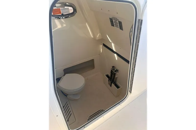 Slide: The Image of Interior view of 2023 Boston Whaler 280 Outrage boat's compact bathroom area. - 14