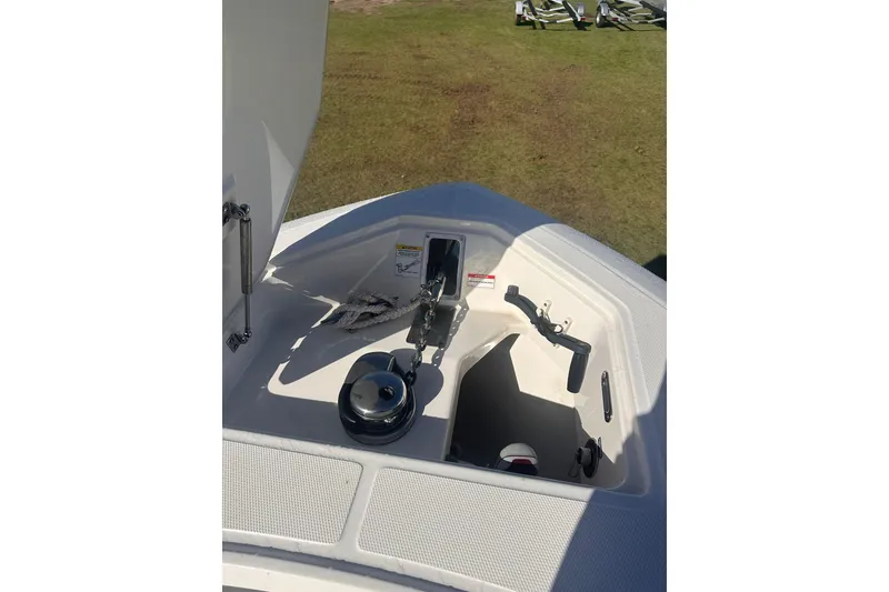 Slide: The Image of 2023 Boston Whaler 280 Outrage anchor compartment with winch and rope on deck. - 18