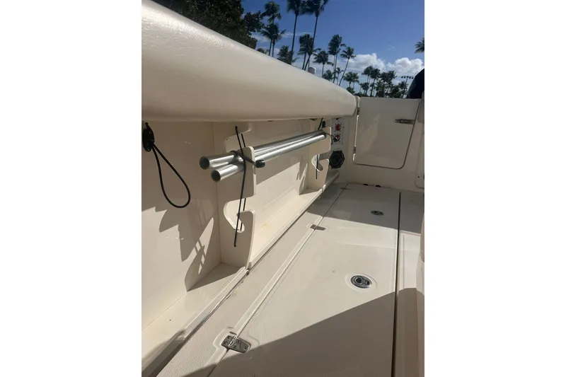 Slide: The Image of 2023 Boston Whaler 280 Outrage interior with rod holders and deck view. - 19