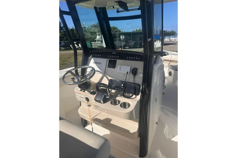 Slide: The Image of 2023 Boston Whaler 280 Outrage helm with steering wheel and navigation equipment. - 9