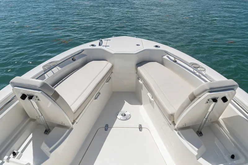 Slide: The Image of Manufacturer Provided Image: 2026 Boston Whaler 280 Dauntless boat interior with cushioned seating, on calm water. - 7