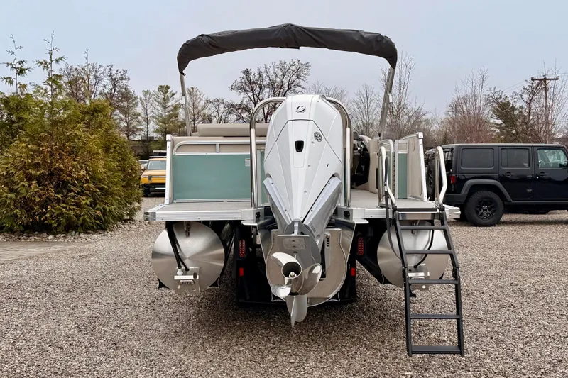Slide: The Image of 2026 Tahoe Pontoon Cascade 25' VRL with outboard motor and ladder, parked on gravel. - 3