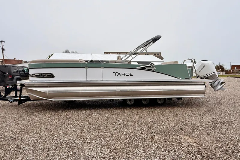 Slide: The Image of 2026 Tahoe Pontoon Cascade 25' VRL on gravel lot, side view with Mercury outboard. - 5