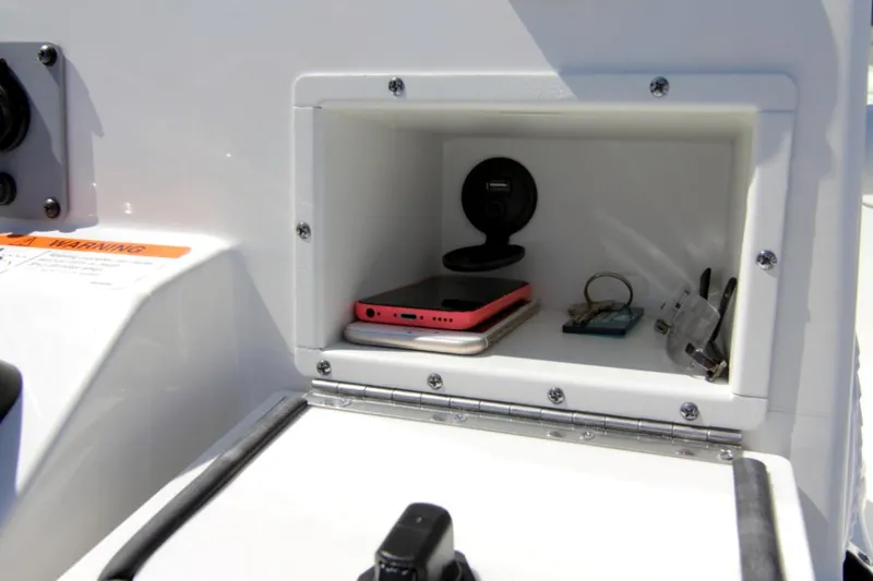 Slide: The Image of Manufacturer Provided Image: Storage compartment on 2025 Sea Born FX24 Bay boat with phone and accessories. - 9